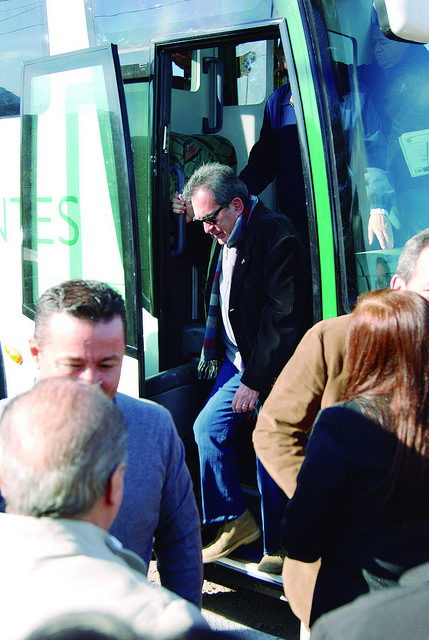 Gobernador de Aguascalientes bajando de autobus rotulado con leyenda e imagen de Gobierno del Estado